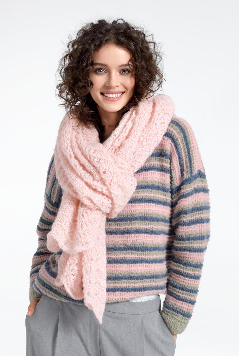 Frau trägt eine rosa Stola aus Aerea vorsichtig um den Hals, lächelnd