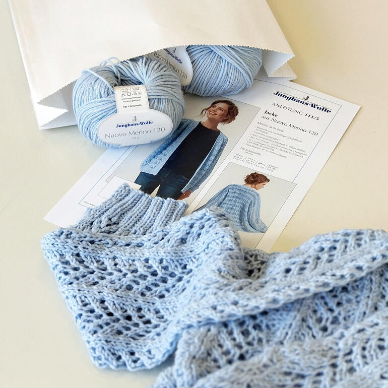 WoolBag Jacke in hellblau, kombiniert mit Garn und Anleitung.