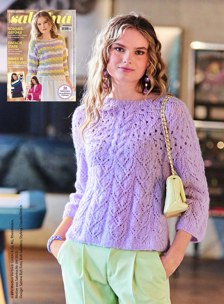 Frau in lila Passenpulli mit Lochmuster, posiert in heller Umgebung.