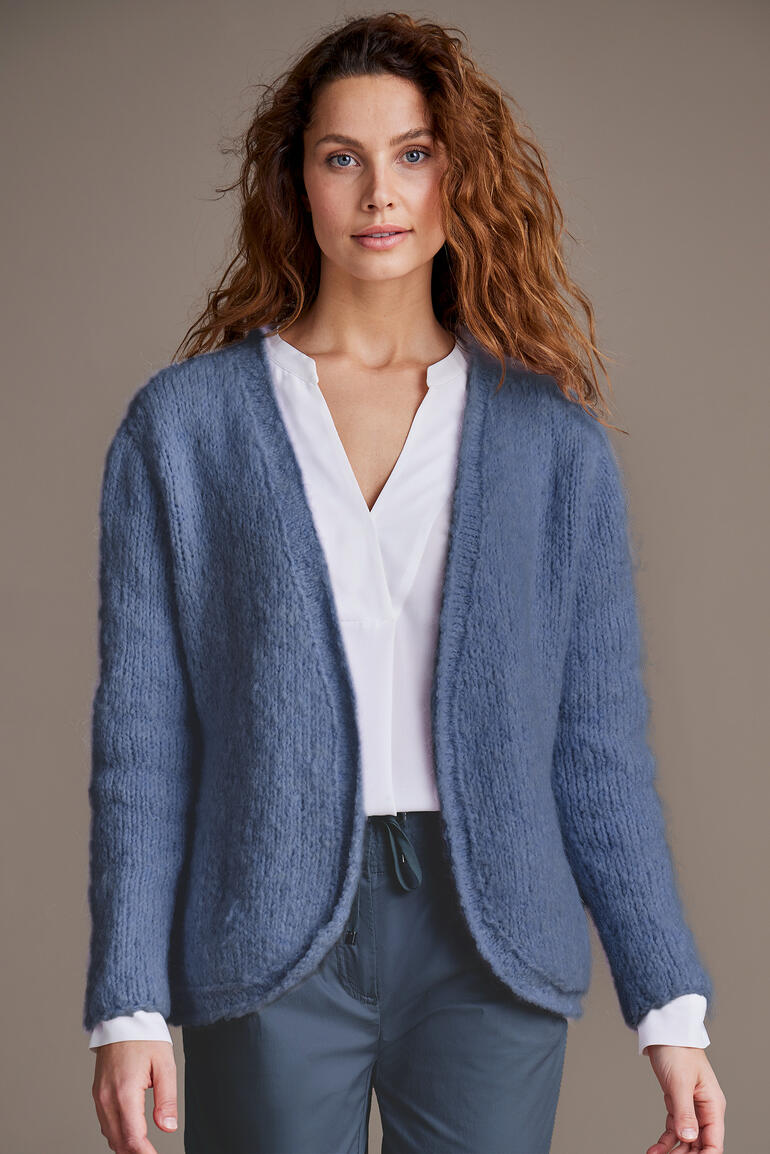 Weiche Jacke aus Nappy von Junghans-Wolle, weibliches Model schaut freundlich.