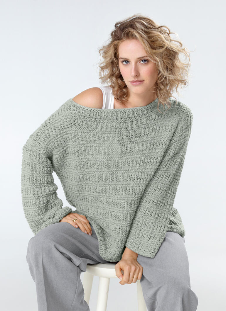 Frau trägt einen farbenfrohen Pullover aus Lotti-Uni mit lockerer Passform.