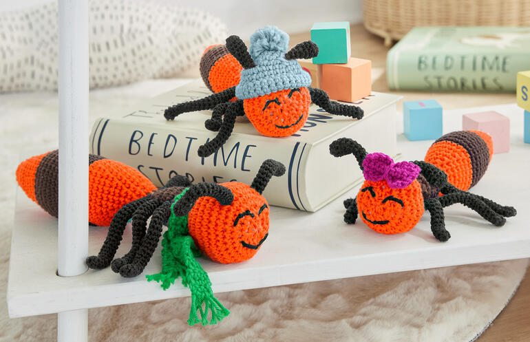 Vier gehäkelte Ameisen „Horst“, „Johannes“ und „Olivia“ mit bunten Hüten und Accessoires.