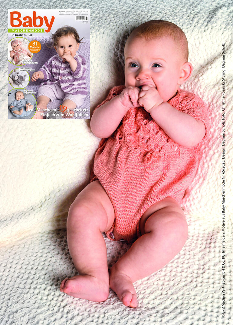Lächelndes Baby in einem rosa Body, sitzt auf einer weißen Decke.