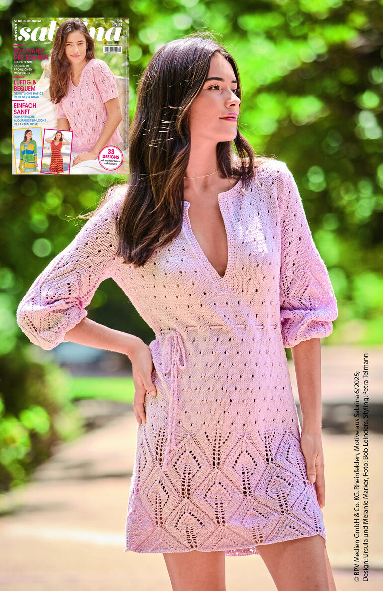 Frau in hübscher Tunika mit tiefem V-Ausschnitt, posiert im Freien.