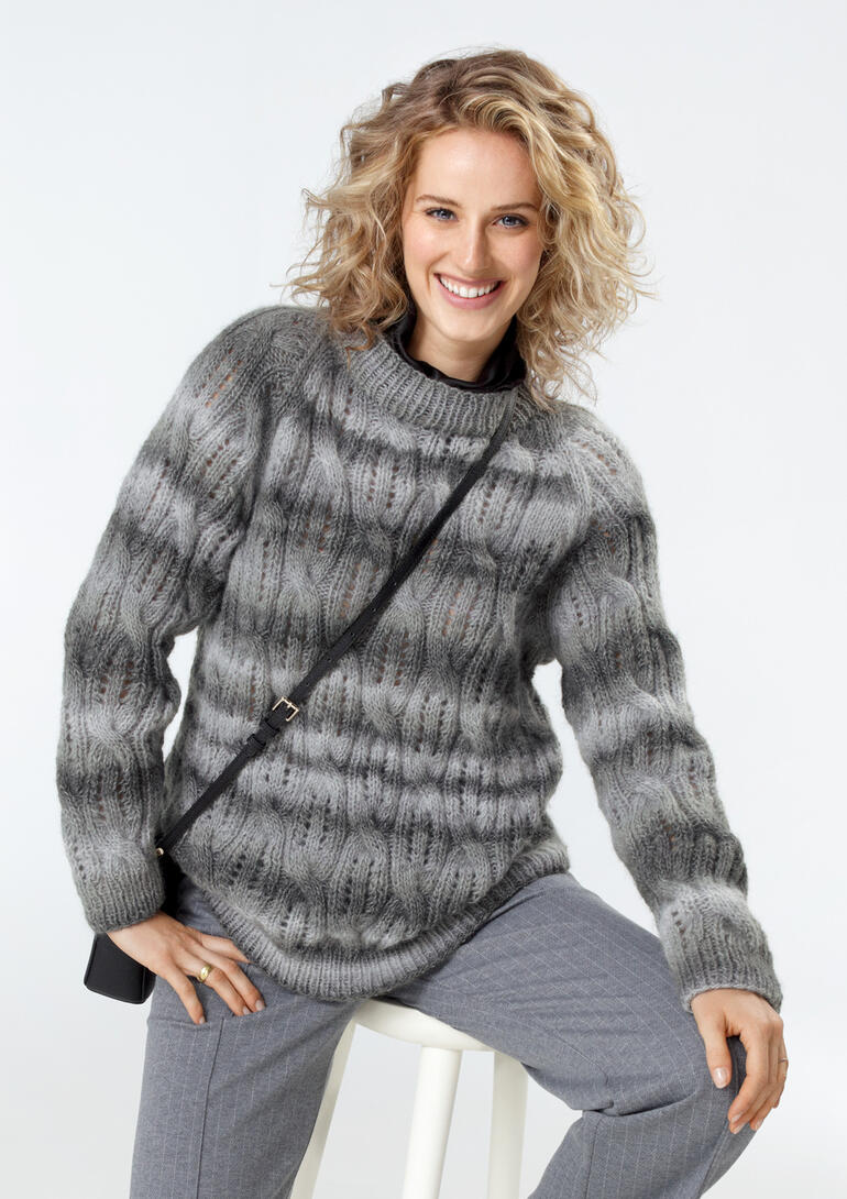 Frau trägt einen grauen Pullover aus Scala mit attraktiven Mustern und lockere Passform.