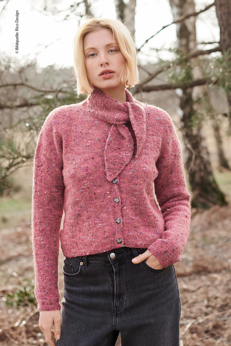 Frau in rosa Jacke mit Bindeband, lächelt im Wald.