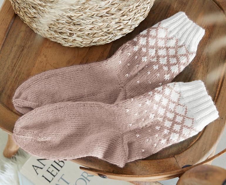 Socken aus Merino-Freizeit 4-fach, zart rosa mit weißem Musterdruck.