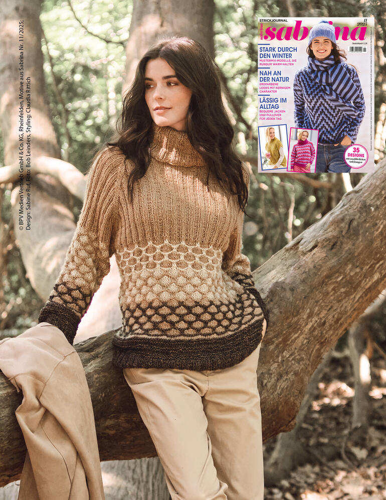 Frau trägt einen Passenpullover mit Rollkragen aus Wool-Cotton, vor Bäumen.