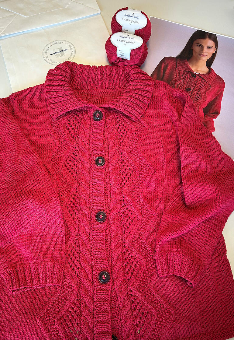 Rote gestrickte Jacke und Wollknäuel, Layout mit Anleitungsheft.