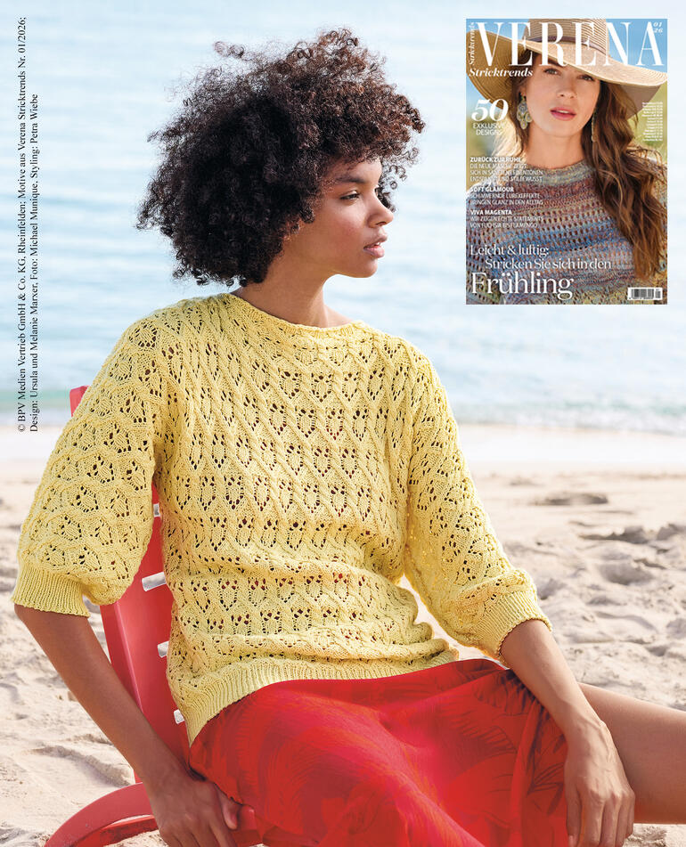 Frau trägt einen gelben Pullover am Strand, Zeitschrift im Hintergrund