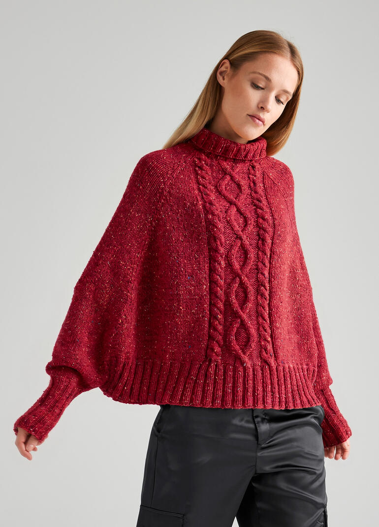 Frau trägt einen Poncho-Pullover aus Punktino von Junghans-Wolle.