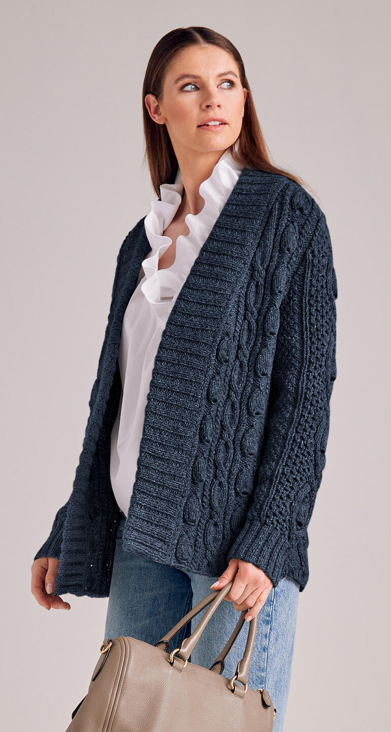 Dunkelblaue Jacke aus Landwolle, kombiniert mit einem weißen Shirt und einer Tasche.