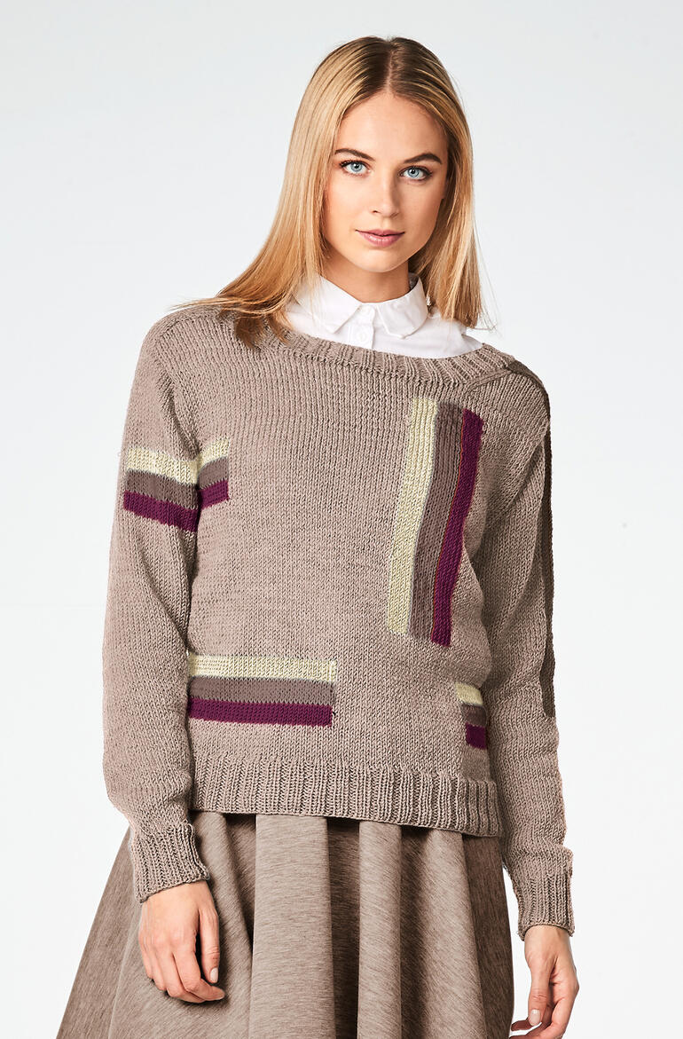 Beiger Pulli aus Merino-Extrafein, getragen von einer Frau mit einem Rock.