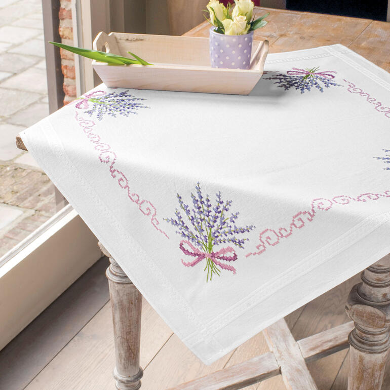 Baumwolltischwäsche mit Lavendelmotiven auf einem Tisch mit einer Blumenvase.