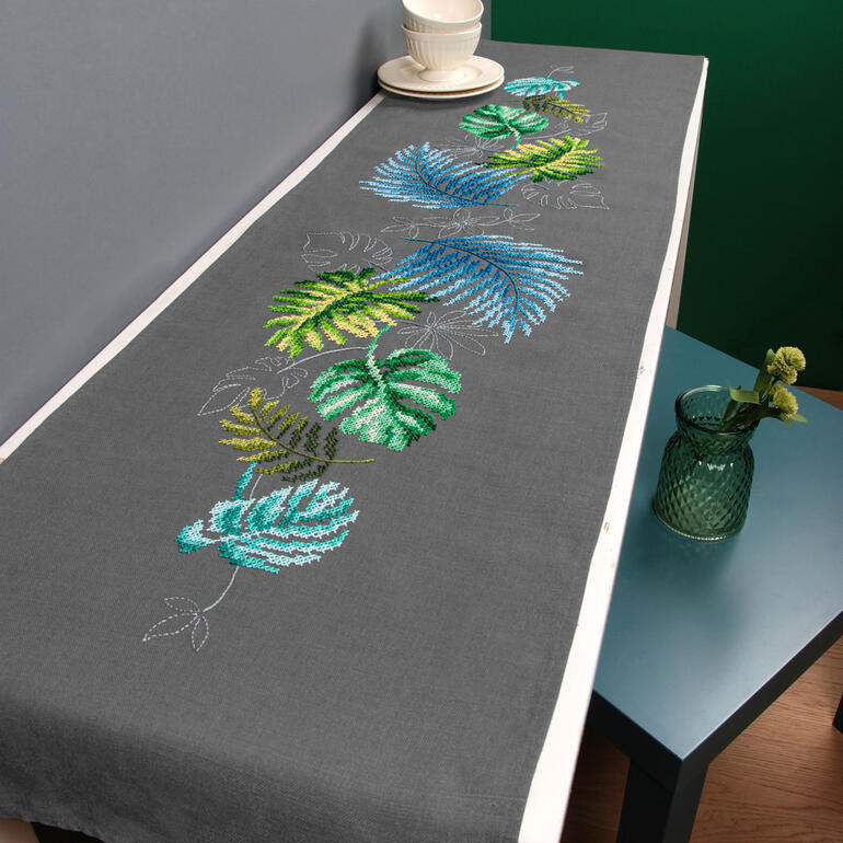 Partnerläufer mit botanischen Blättern in Blau und Grün auf grauem Stoff.