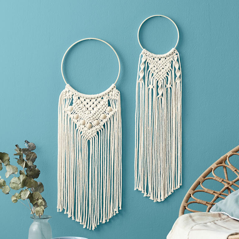 Zwei Makramee-Wanddekorationen in Naturfarben an Wand