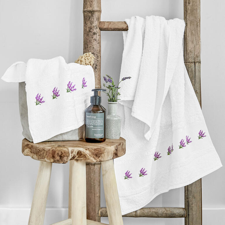 Frottierware mit Lavendelstickerei auf einem Handtuchhalter