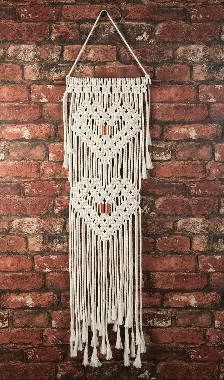 Makramee-Wandbehang mit Herzmotiven in Weiß.