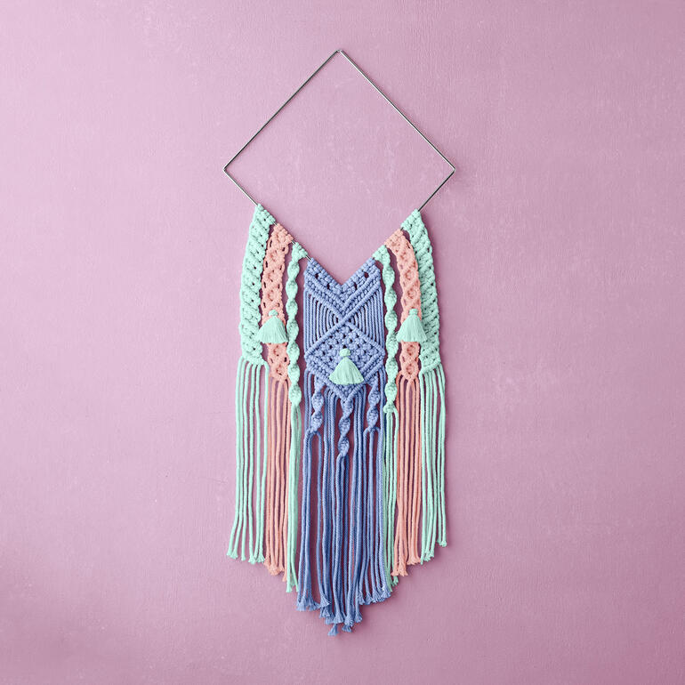 Buntes Makramee Wandbehang als Kunstwerk an einer Wand.