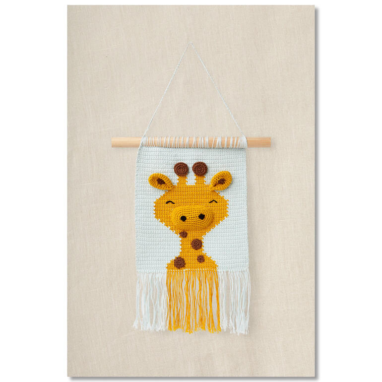 Wandbehang mit Giraffenmotiv an einer Wand aufgehängt.