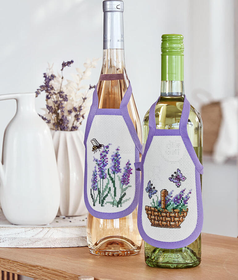 Zwei Flaschenschürzen mit buntem Blumenmuster für Weinflaschen.