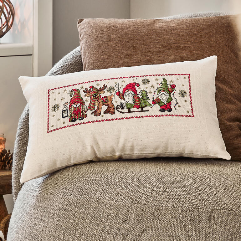 Kissenhülle mit Wichtelmotiven im Winter, weihnachtliche Atmosphäre mit Geschenken.