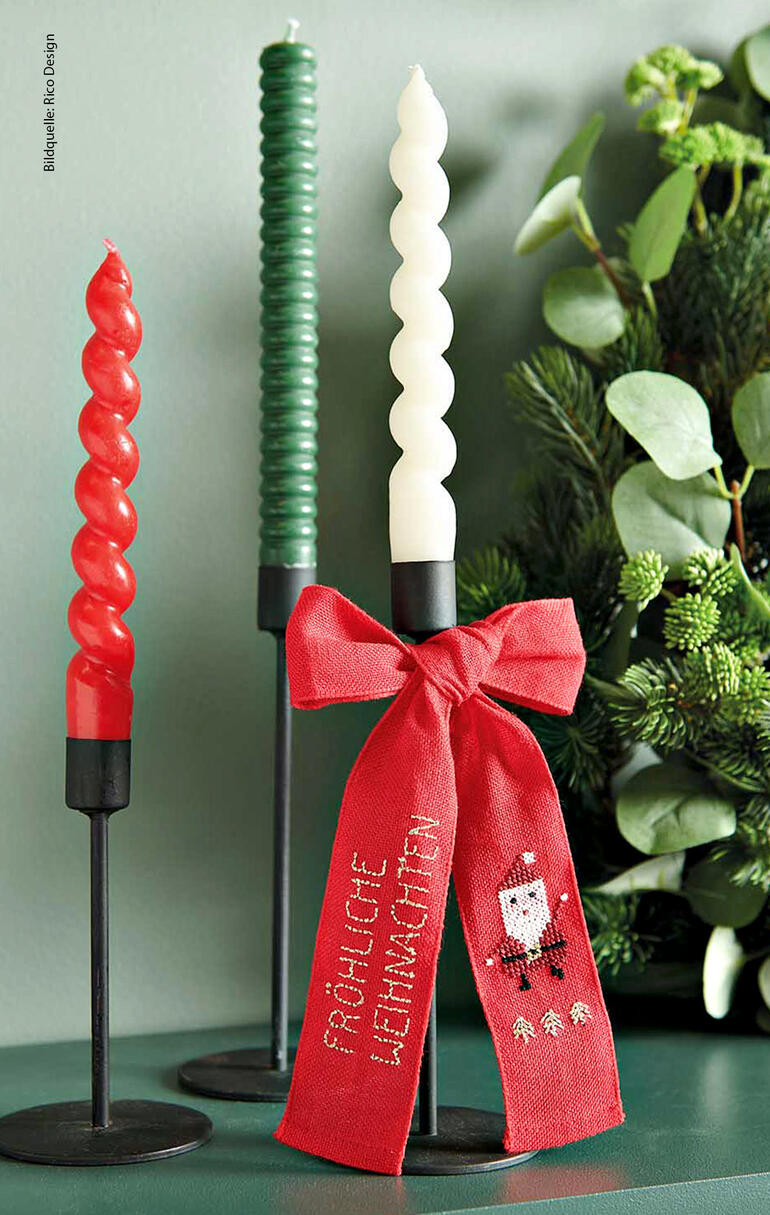 Schleife mit Weihnachtsmann-Verzierung um Kerzenhalter.