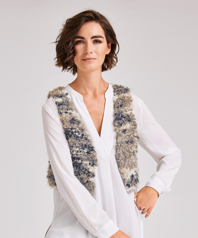 Weste aus Bo. in grau-beige, modisch getragen von einer Frau in blauer Bluse.
