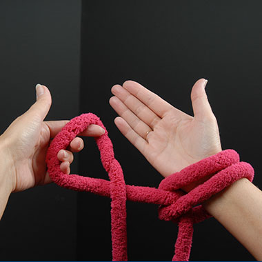 So oft wiederholen, bis die gewünschte Anzahl Schlaufen auf dem rechten Arm liegen.