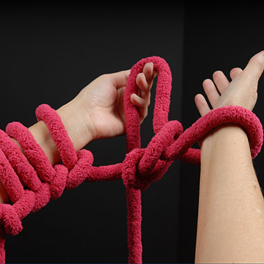 Anschließend die nächste Schlaufe vom linken Arm nehmen und in gleicher Weise abstricken wie zuvor, d.h. die Schlaufen auf den rechten Arm legen.