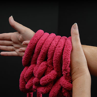 Nun wieder mit der linken Hand durch die Schlaufen greifen und auf den linken Arm zurücklegen.